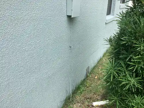 Grounding electrode conductor running down the stucco exterior of a Longwood home from the panel to a driven ground rod