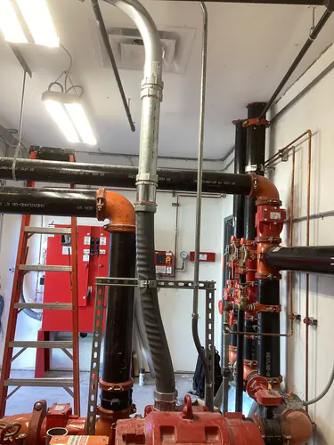 Fire pump room piping and galvanized conduit feeding the fire pump controller at the EMS warehouse