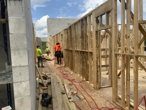 Crew working along a wood framed exterior wall on the Hawthorne Heights apartment deck