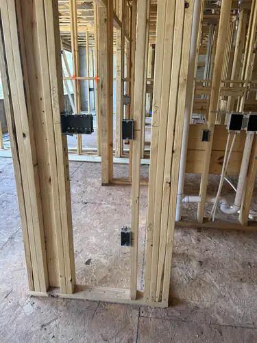 Device boxes nailed to the studs of a framed apartment wall at Hawthorne Heights