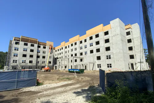Five story Hawthorne Heights apartment building under construction with block walls and wood framed upper floors
