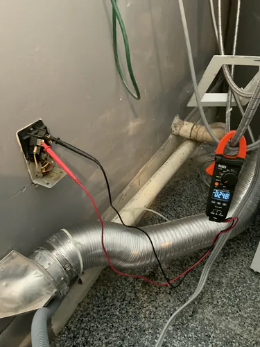 Klein Tools clamp meter reading 248 volts across the old dryer receptacle in a Maitland laundry area