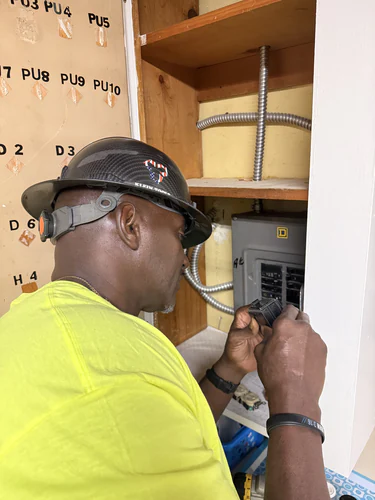 Technician preparing a receptacle at the Square D load center during the Winter Park home office wiring