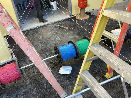 Wire reels set on jack stands with pull lines run into the Massey Cadillac building