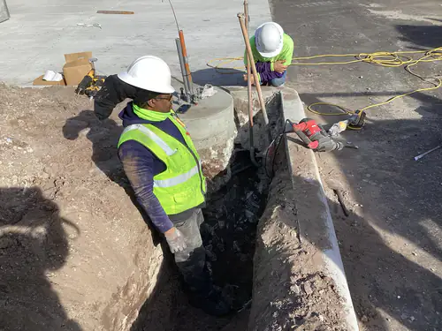 Crew core drilling and breaking concrete for a light pole base at Massey Cadillac