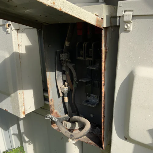Rusted Orlando disconnect enclosure with the old main breaker removed and the stranded load conductor pulled back