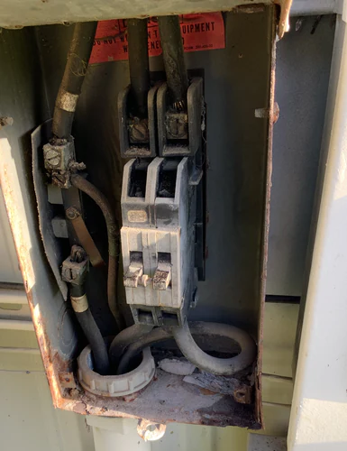 Corroded two pole 100 amp main breaker inside a rusted outdoor disconnect enclosure in Orlando