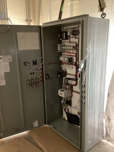 Motor control cabinet opened to show the control wiring, contactors and terminal blocks
