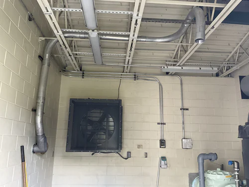 Galvanized conduit runs feeding a wall exhaust fan and disconnects at the Hunter's Creek water facility