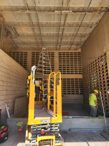 Scissor lift and ladder set up in the louvered equipment bay at the Hunter's Creek water facility