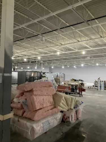Interior of the Lady Lake Market with the roof structure lit and refrigeration cases being set