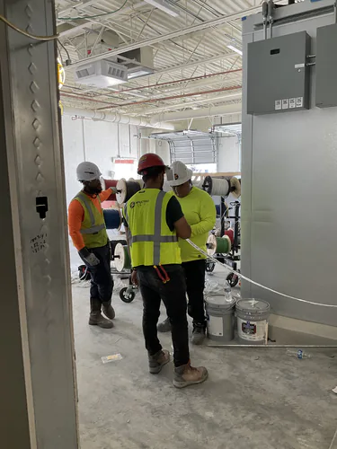 Spectrum Electric crew staging wire carts beside the panels in the Lady Lake Market electrical room