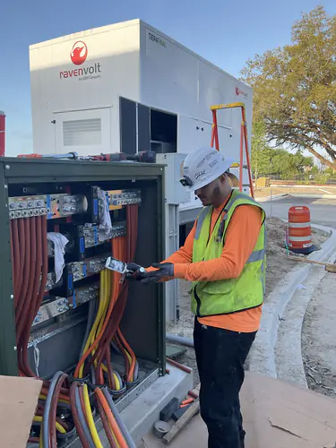 Electrician terminating feeders in the switchgear beside the RavenVolt generator at Lady Lake Market