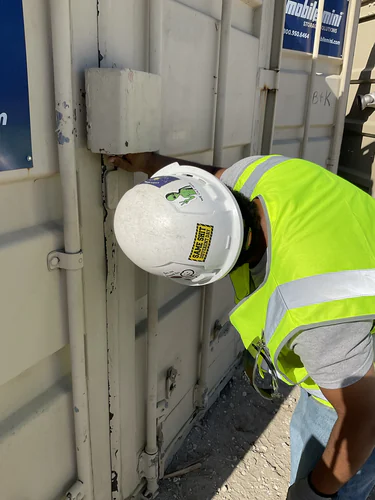 Electrician wiring a temporary power box on a job site storage container at Lady Lake Market
