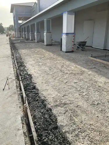 Curb forms and canopy columns along the front of the Lady Lake Market before paving