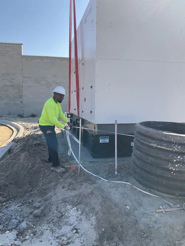 Electrician setting the RavenVolt standby generator on its pad at Lady Lake Market